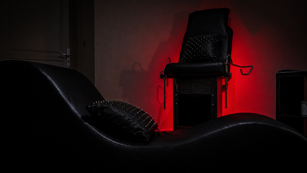 Fauteuil tantra dans la suite de L’Atelier Kuroi, halo rouge.