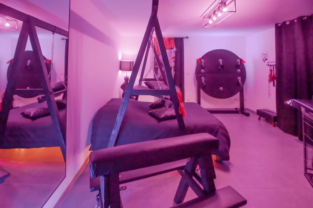 Vue de la suite de L’Atelier Kuroi avec lit suspendu et miroir, lumière feutrée.